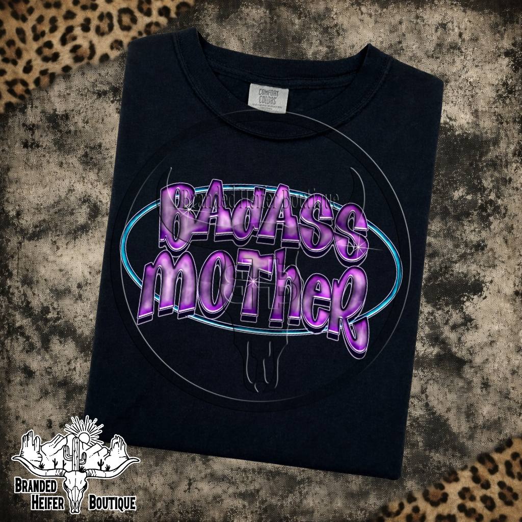 Badass Mother Neon Graphic Tee in Black, purple chrome Badass Mother lettering in a neon blue oval, printed on a Comfort Colors tee